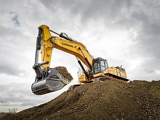 Gelber LiuGong Kettenbagger beim Bewegen von Erde auf einer Baustelle