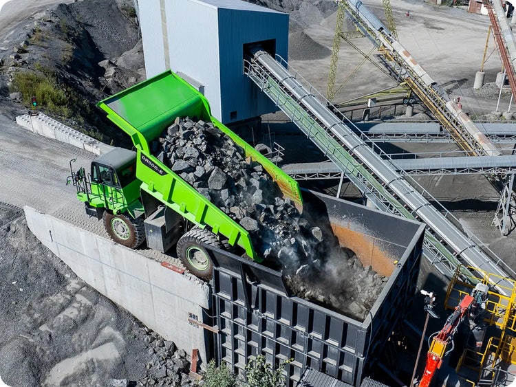 LiuGong DR50C der eine Ladung Steine in einen Brecher kippt in einem Steinbruch.